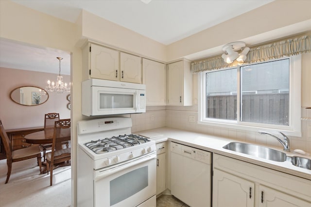 kitchen featuring a chandelier, light countertops, decorative backsplash, white appliances, and a sink