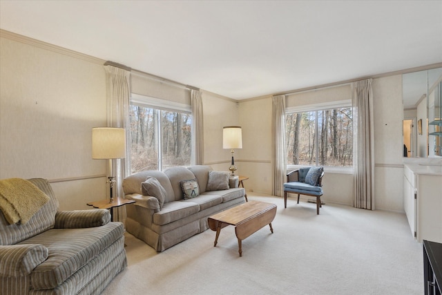 living area with a wealth of natural light, light carpet, and ornamental molding