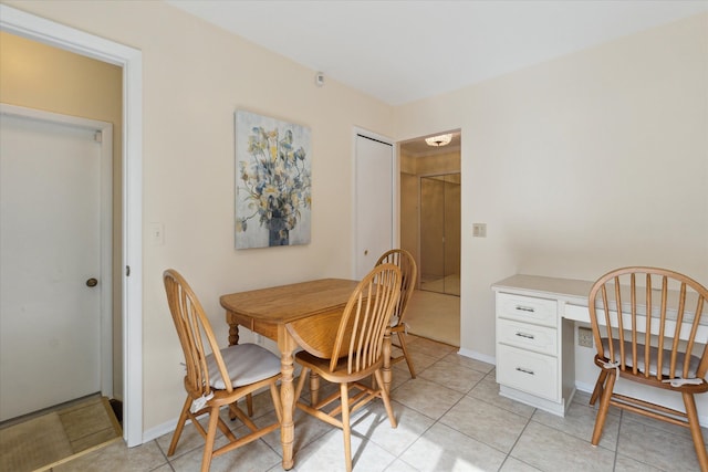 dining space with light tile patterned floors and baseboards