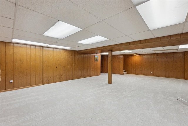 finished basement featuring wood walls and carpet