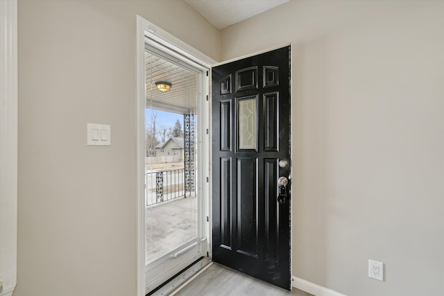 foyer entrance featuring light wood-style floors and baseboards