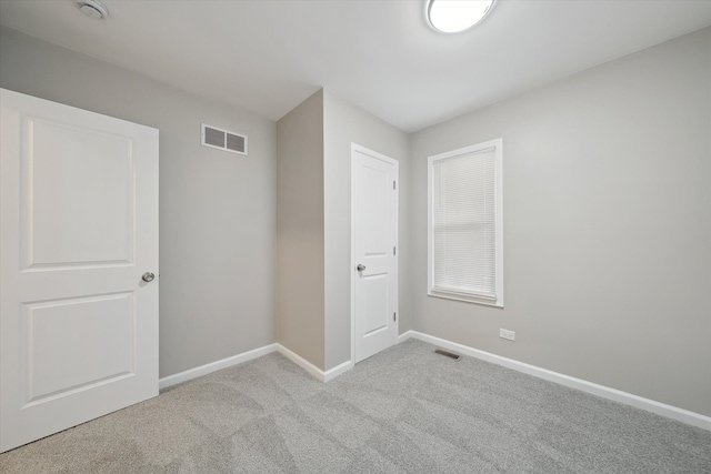 spare room with visible vents, baseboards, and carpet