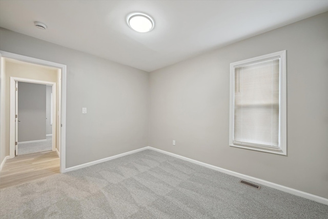 empty room featuring visible vents, baseboards, and carpet floors