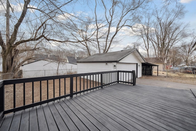 wooden terrace featuring an outdoor structure, fence, and a garage