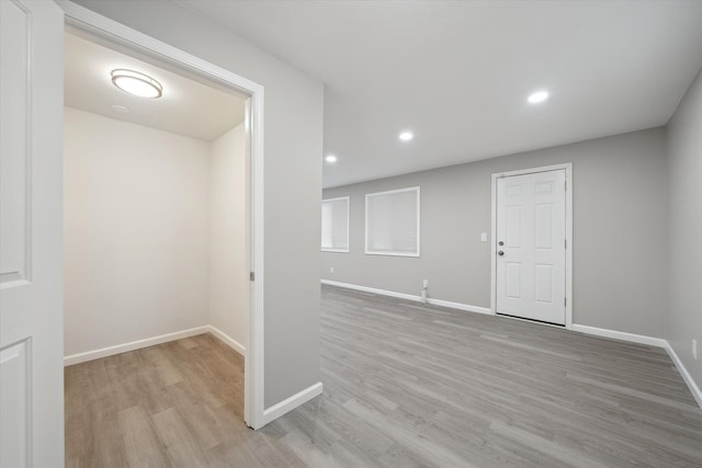 spare room featuring recessed lighting, baseboards, and light wood finished floors