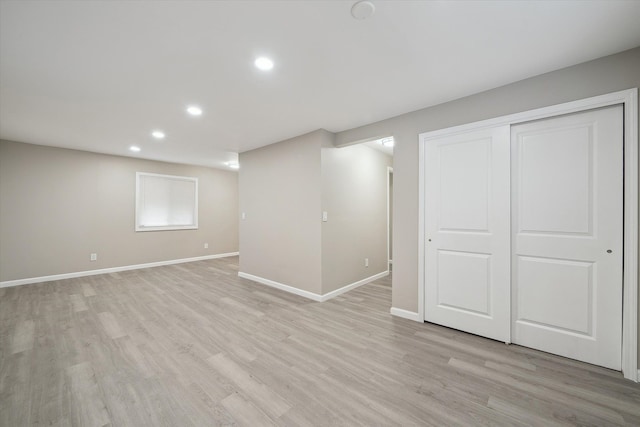 below grade area with recessed lighting, baseboards, and light wood-style floors