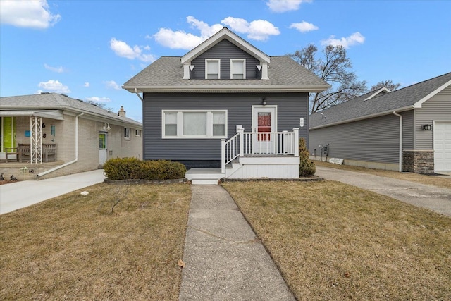 bungalow-style house with roof with shingles and a front lawn