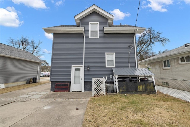 rear view of property featuring a lawn