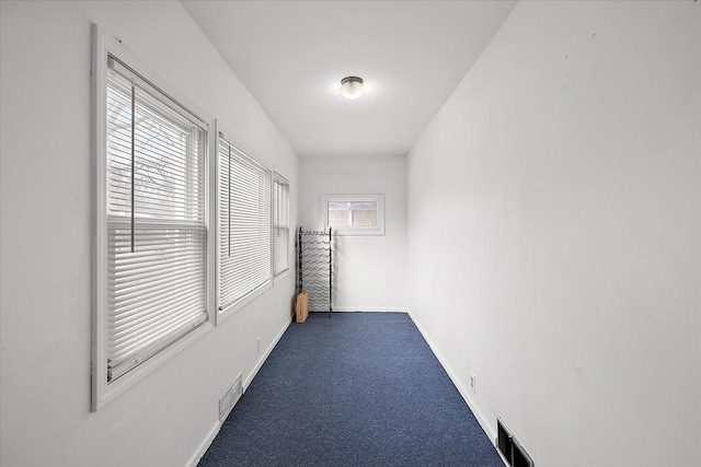 empty room with carpet flooring, baseboards, and visible vents