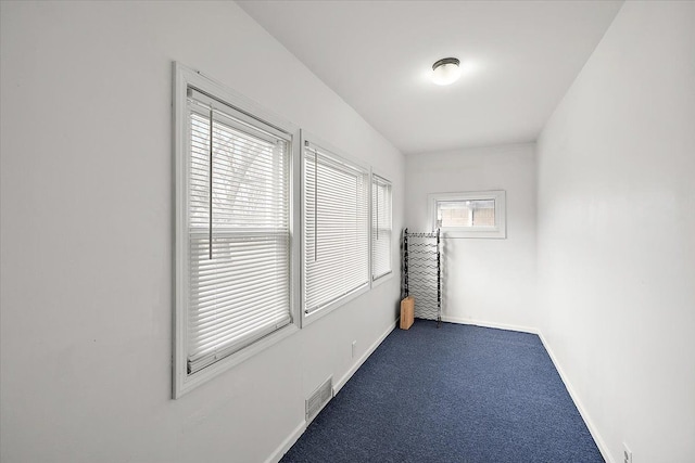 empty room with visible vents, baseboards, and carpet