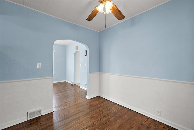 spare room with visible vents, wood finished floors, arched walkways, baseboards, and ceiling fan