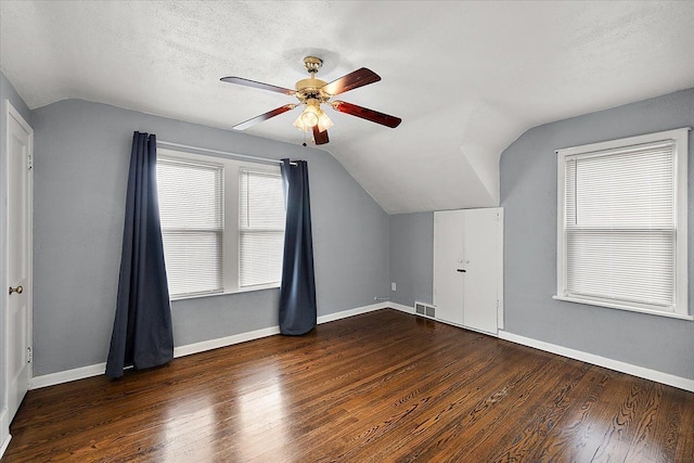 additional living space with visible vents, baseboards, a textured ceiling, and wood finished floors