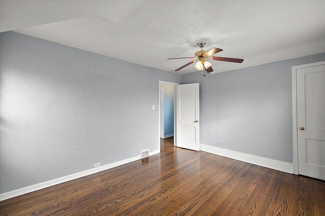 empty room with dark wood-style floors, baseboards, and ceiling fan