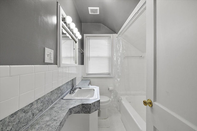 bathroom featuring tile patterned flooring, visible vents, toilet, shower / bath combo, and tile walls