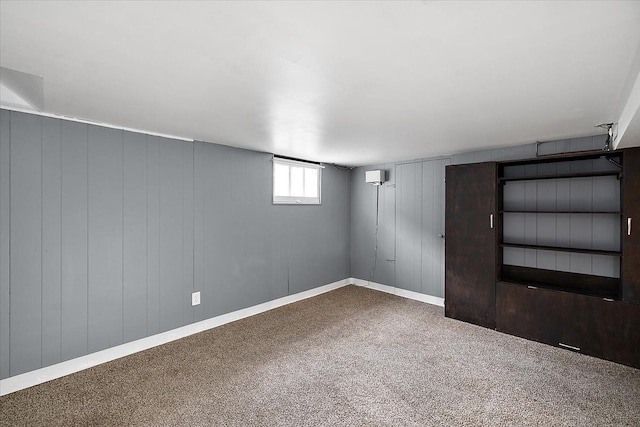 below grade area featuring baseboards and carpet flooring