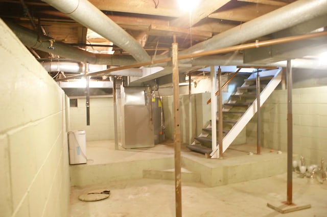 unfinished below grade area featuring heating unit and stairs