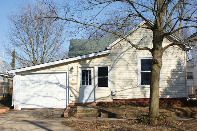 exterior space with driveway and roof with shingles