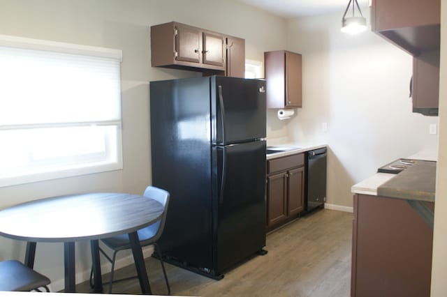 kitchen with baseboards, black appliances, and light wood-style flooring