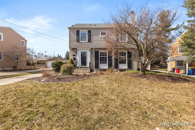 colonial inspired home featuring a chimney and a front lawn