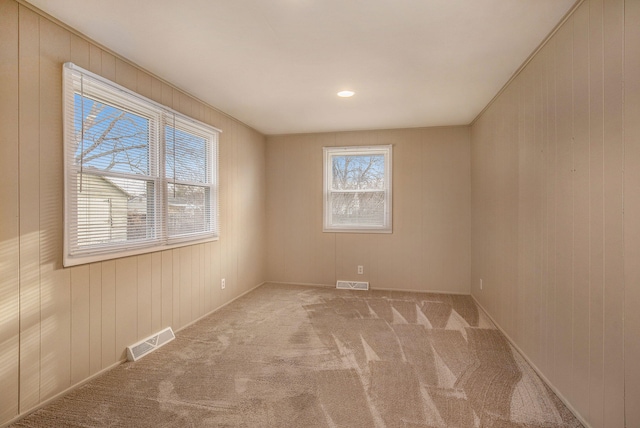 empty room featuring visible vents and carpet floors