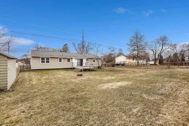 back of property featuring a lawn, a fenced backyard, and a wooden deck