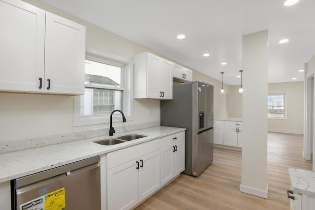 kitchen featuring a sink, stainless steel appliances, white cabinets, and light wood finished floors