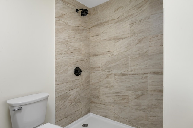 full bath featuring toilet and tiled shower