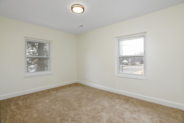 spare room featuring baseboards and carpet flooring