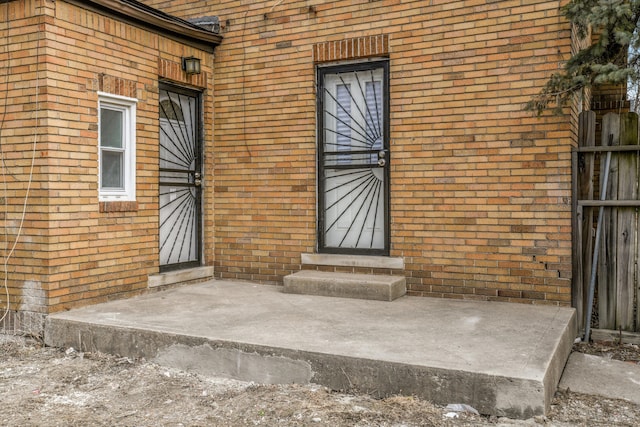 doorway to property featuring brick siding