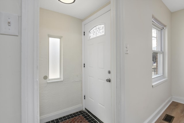 foyer featuring baseboards and visible vents