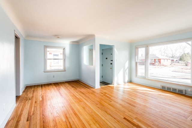 empty room with visible vents, baseboards, and light wood-style flooring