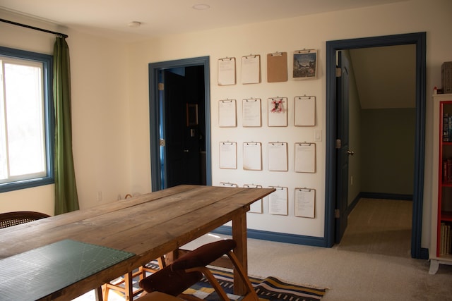 carpeted dining space with baseboards