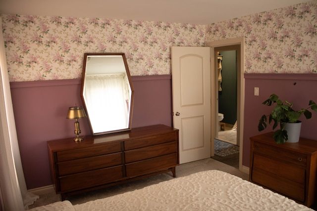 bedroom featuring a wainscoted wall and wallpapered walls