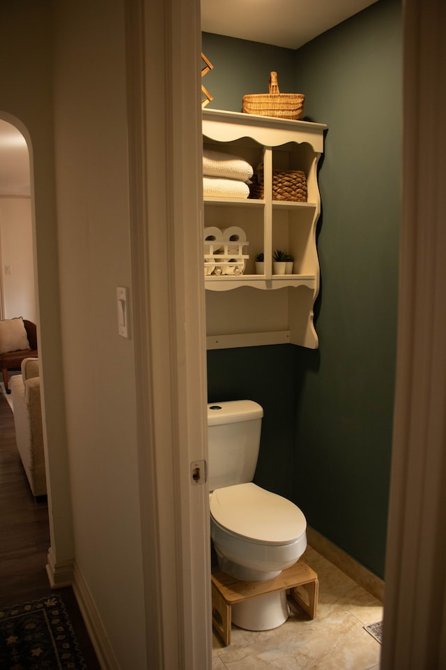 bathroom with toilet and baseboards