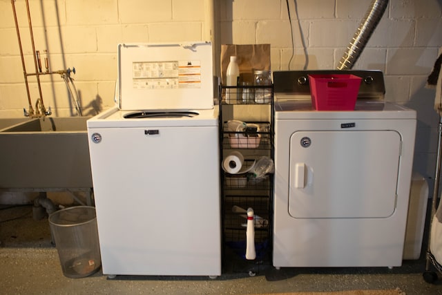 washroom featuring washer and clothes dryer, laundry area, and a sink