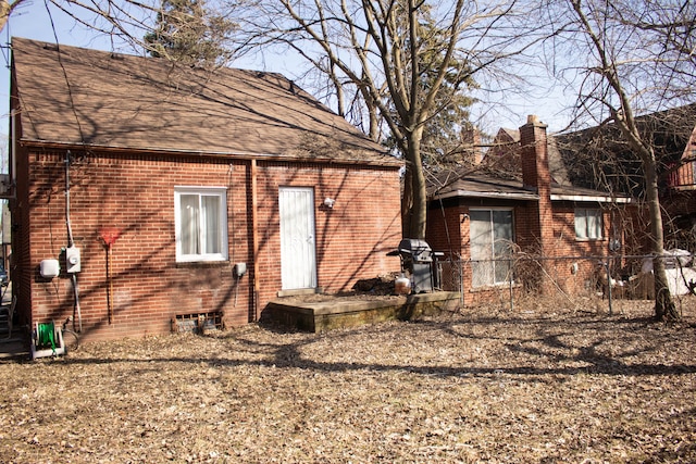 view of side of home featuring brick siding, a chimney, and a shingled roof