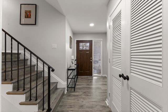 foyer with recessed lighting, stairs, baseboards, and wood finished floors