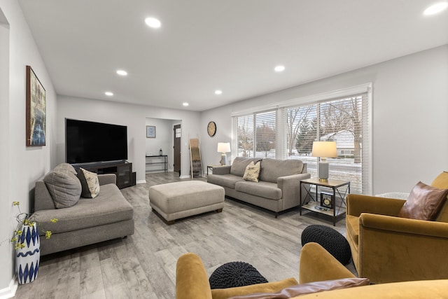 living area featuring recessed lighting, baseboards, and light wood-style floors