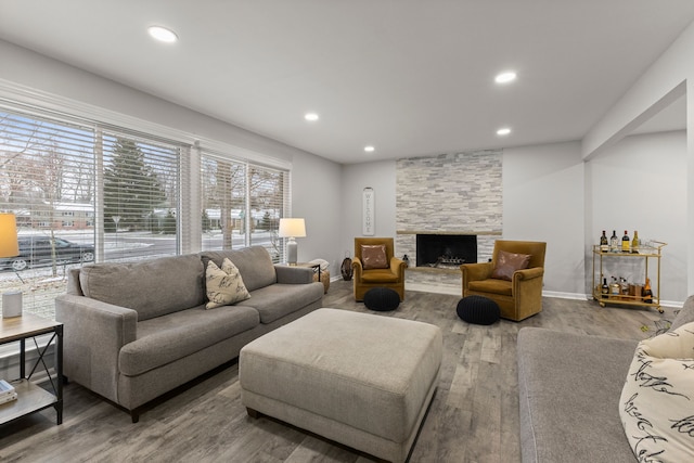 living area featuring recessed lighting, baseboards, wood finished floors, and a fireplace