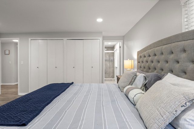 bedroom with recessed lighting, baseboards, two closets, and wood finished floors