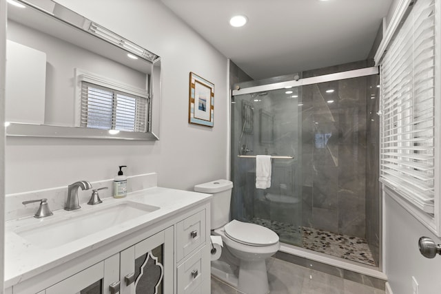 full bathroom with a stall shower, toilet, and vanity