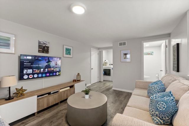 living room featuring dark wood-type flooring, baseboards, and visible vents