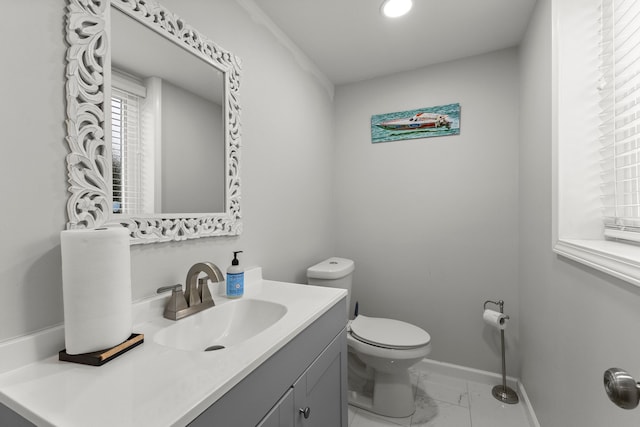 bathroom featuring marble finish floor, toilet, vanity, and baseboards