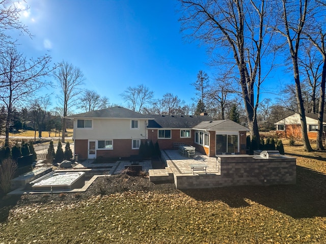 rear view of property featuring a patio, a fire pit, and an outdoor kitchen