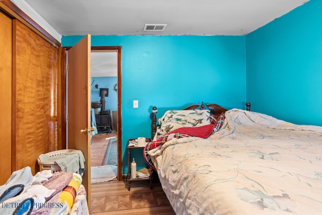 bedroom with a wood stove and visible vents