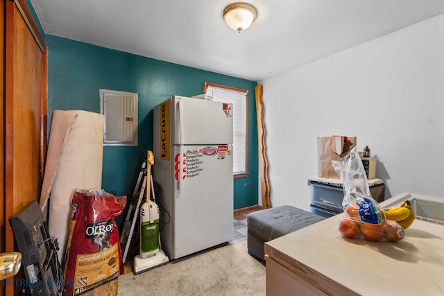 kitchen featuring electric panel, light colored carpet, and freestanding refrigerator