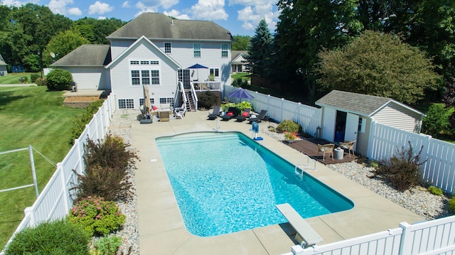 view of swimming pool with a patio, a fenced backyard, a yard, an outdoor structure, and a fenced in pool