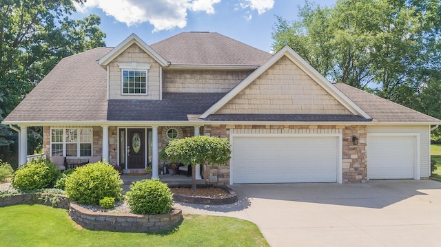 craftsman inspired home featuring stone siding, driveway, a porch, and an attached garage