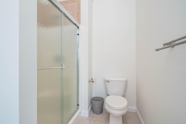 full bath with tile patterned floors, a stall shower, toilet, and baseboards