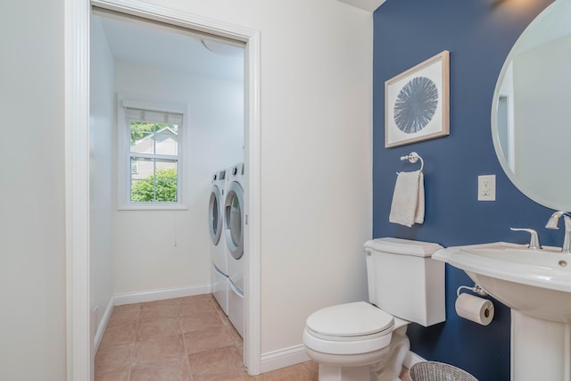 bathroom featuring tile patterned floors, toilet, independent washer and dryer, a sink, and baseboards